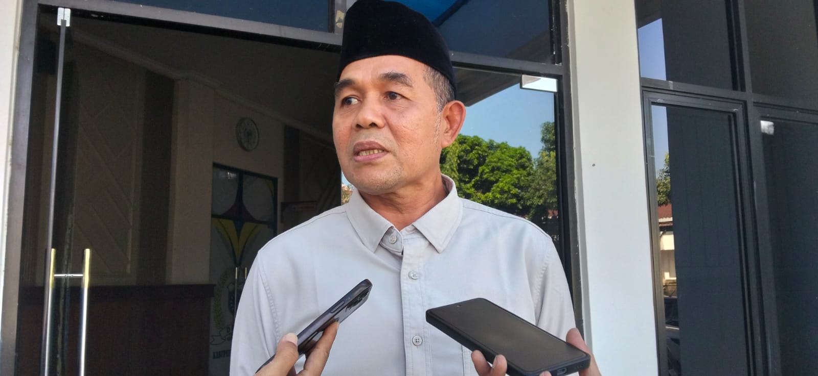 WAWANCARA. Ketua Komisi IV DPRD Pandeglang, Tb. Udi Juhdi, sedang diwawancara wartawan terkait banyaknya temuan BPK RI di Disdikpora Pandeglang, di lingkungan Kantor DPRD Pandeglang, Kamis (23/7). (NIPAL SUTIANA/TANGSEL POS)