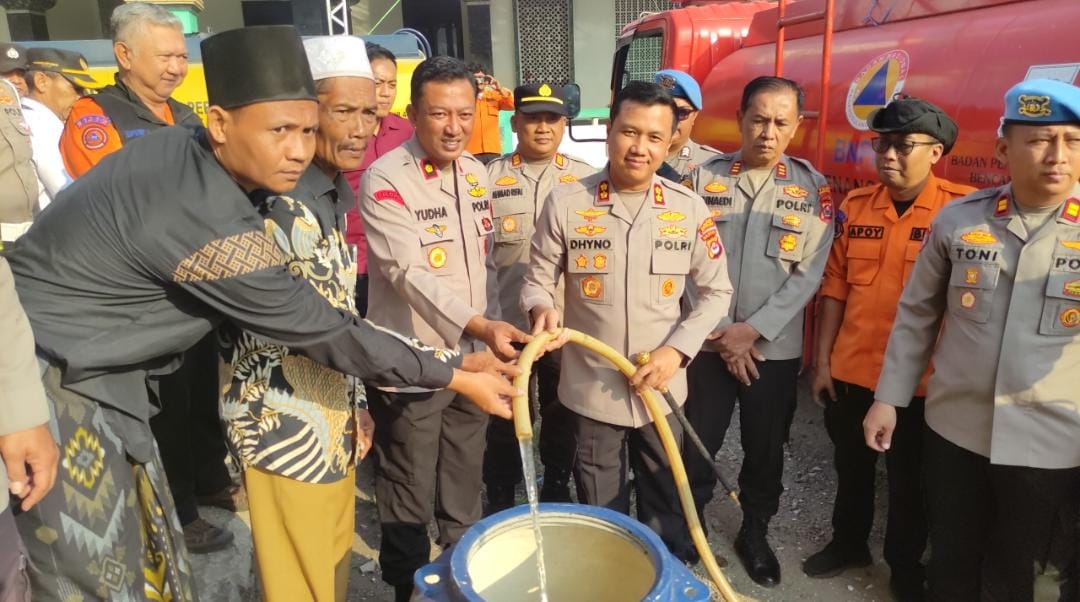 KUCURKAN AIR. Kapolres Pandeglang, AKBP Dhyno Indra Setyadi didampingi jajarannya, sedang mengucurkan bantuan air bersih kepada warga Kampung Cisampih, Desa Pakuluran, Kecamatan Koroncong, Kabupaten Pandeglang, Kamis (23/7). (ISTIMEWA)
