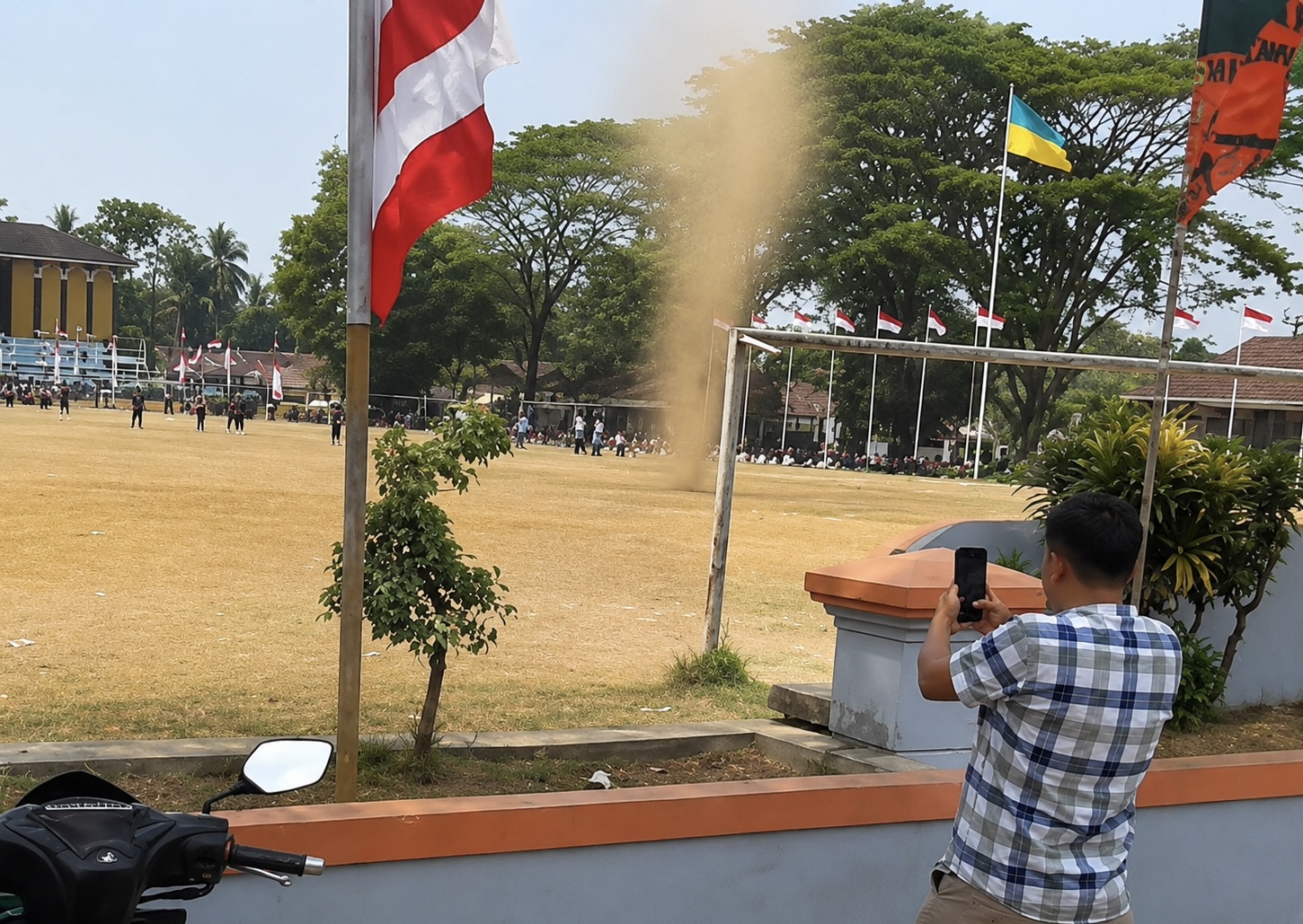 MENGABADIKAN. Salah seorang warga yang sedang berada di sekitaran Alun-alun Menes, Kecamatan Menes, Kabupaten Pandeglang, sedang mencoba mengabadikan angin puyuh menggunakan kamera handphone-nya, Kamis (13/8). (DOK. WARGA)