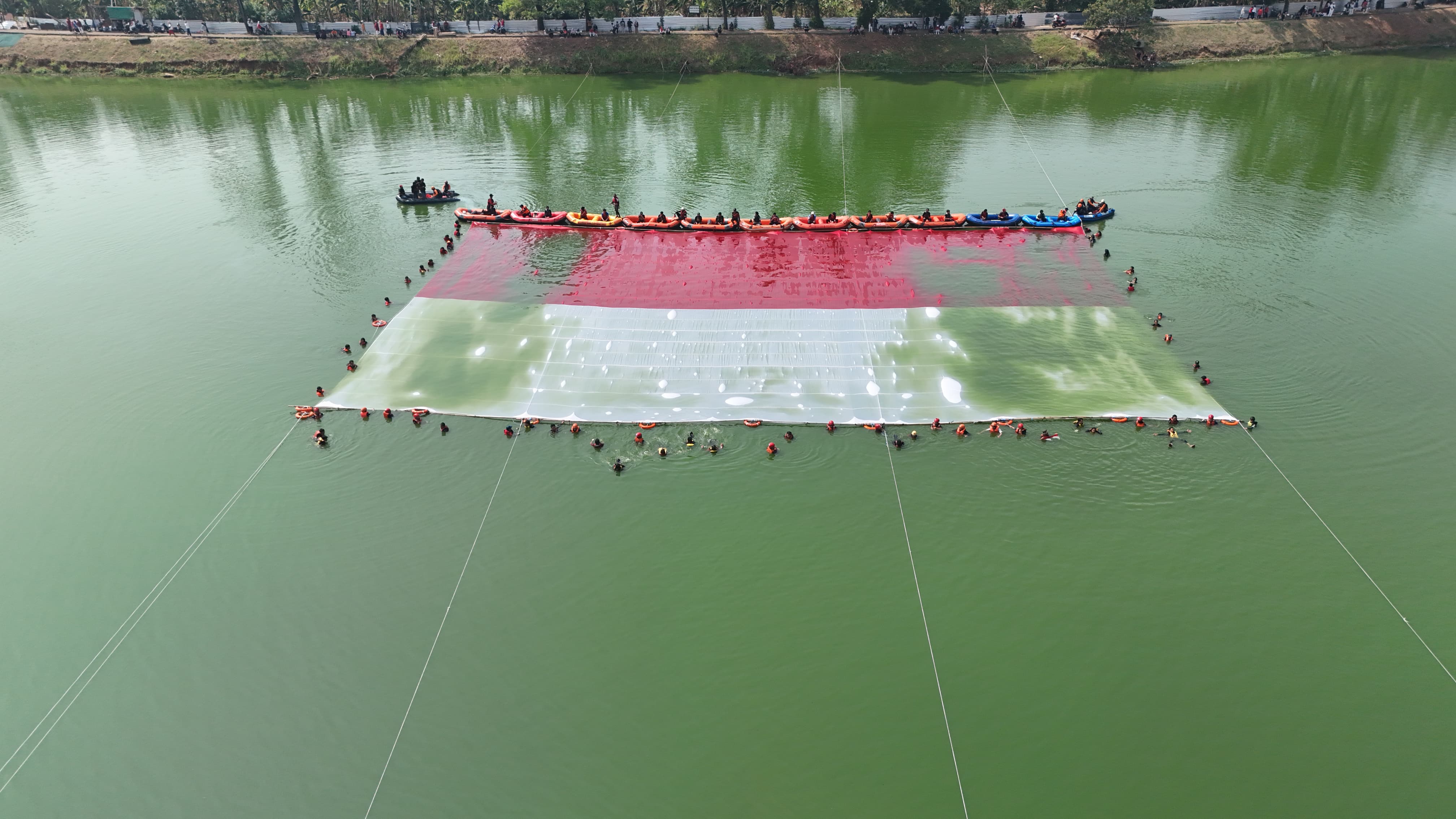Ratusan relawan membentangkan bendera Merah Putih berukuran raksasa di Situ Gintung, Kecamatan Ciputat Timur, Kota Tangerang Selatan, Senin (17/8/2026). (Ist)