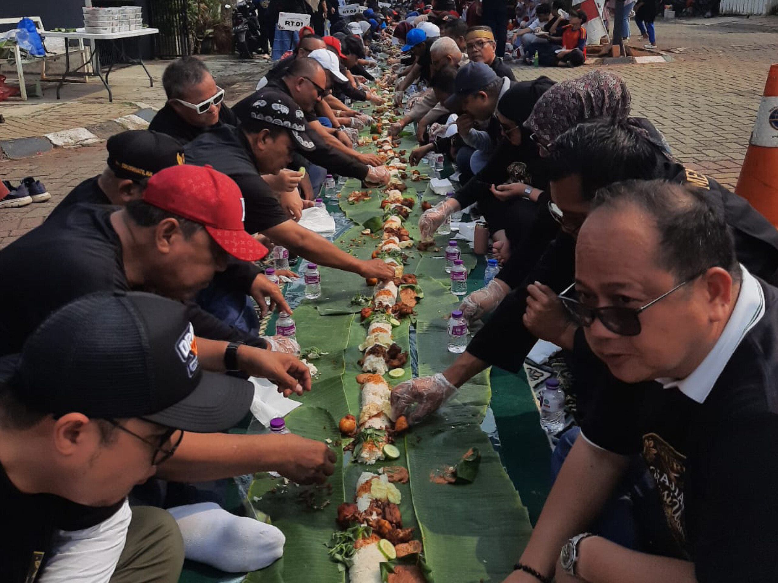 Warga RW 06 Panorama Serpong menikmati sajian Nasi Ulam Tangsel terpanjang sepanjang 81 meter pada Minggu (23/8/2026). (Ist)