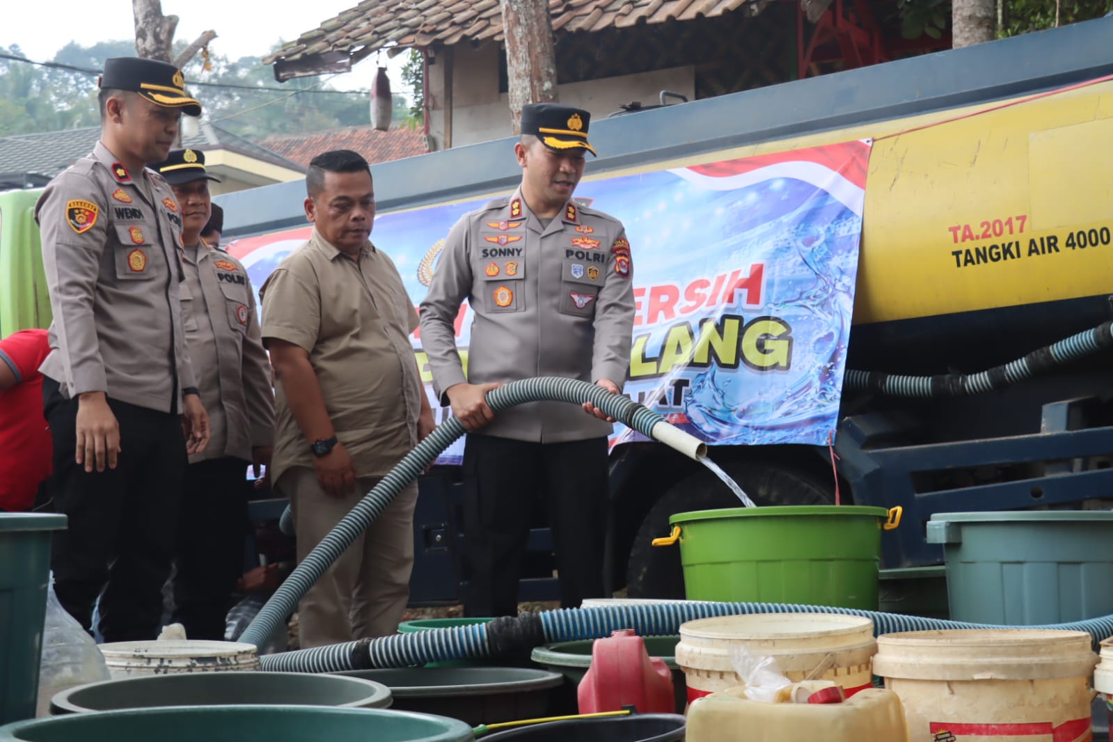 BANTU AIR BERSIH. Kapolres Pandeglang AKBP Sonny Harsono, sedang mengucurkan bantuan air bersih secara bergantian ke ember milik masyarakat, di Kampung Campuraksanta RT/RA 003/007, Kelurahan Pagerbatu, Kecamatan Majasari, Kabupaten Pandeglang, beberapa waktu lalu. (DOK. HUMAS POLRES PANDEGLANG)