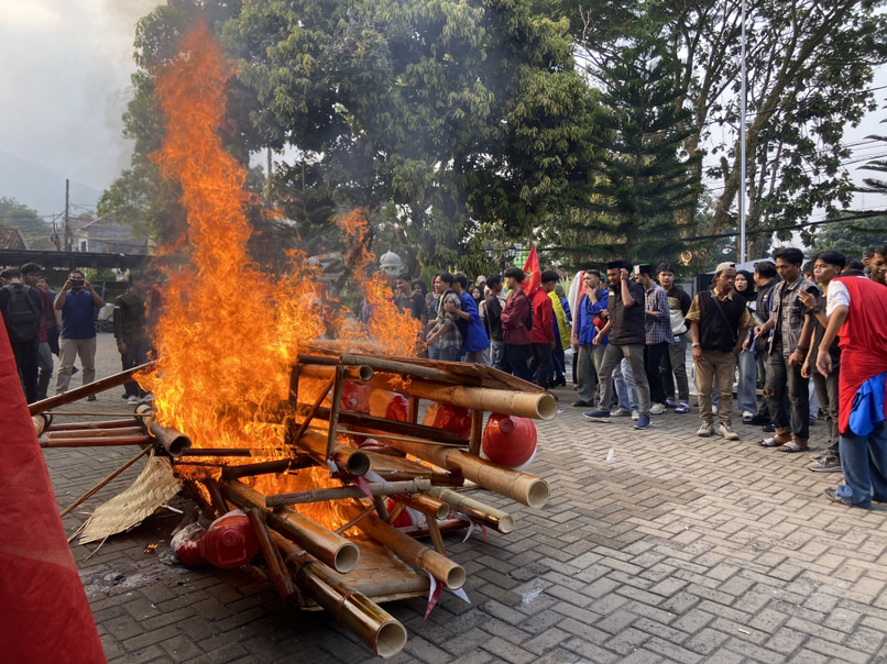 BAKAR GAPURA. Mahasiswa yang melakukan demonstrasi di halaman Gedung DPRD Pandeglang, telah membakar hiasan gapura terbuat dari bambu milik DPRD Pandeglang dan ban bekas, Kamis (3/9). (NIPAL SUTIANA/TANGSEL POS)