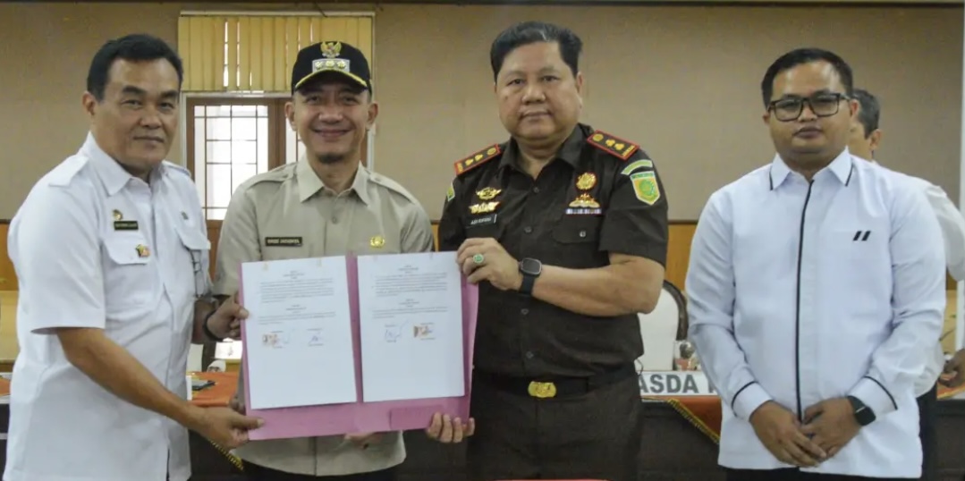 MENUNJUKAN. Bupati Lebak, Moch. Hasbi Asyidiki Jayabaya, bersama pihak Kejari Pandeglang dan jajaran lainnya, menunjukan Nota Kesepakatan antara Pemkab Lebak dengan Kejari Lebak, tentang Penanganan Masalah Hukum di Bidang Perdata dan Tata Usaha Negara, di Aula Multatuli Sekretariat Daerah (Setda) Lebak, Rabu (9/9). (DOK. PROKOPIM SETDA LEBAK)