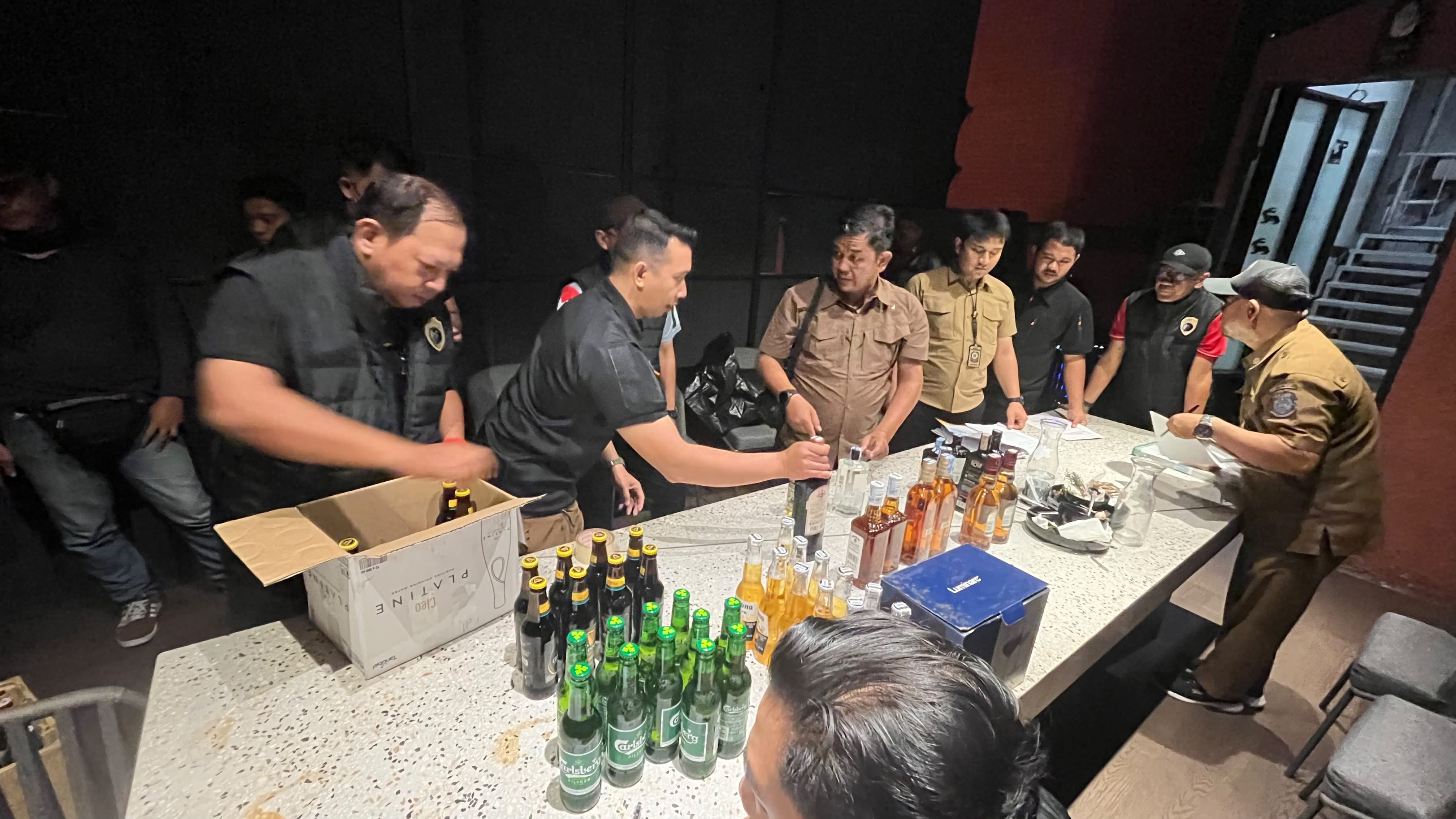 Petugas mengamankan sebanyak 281 botol minol dari dua lokasi yang berada di kawasan Jalan Raya Serpong dan Alam Sutera. (tangselpos/rmn)