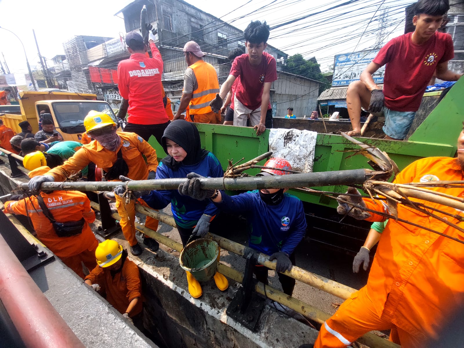 Lurah Cipayung, Dini Nurlianti bersama ratusan relawan saat mengangkut sampah yng menumpuk di aliran sungai tepat di bawah Kolong Flyover Ciputat. (TangselPos/Rahman)