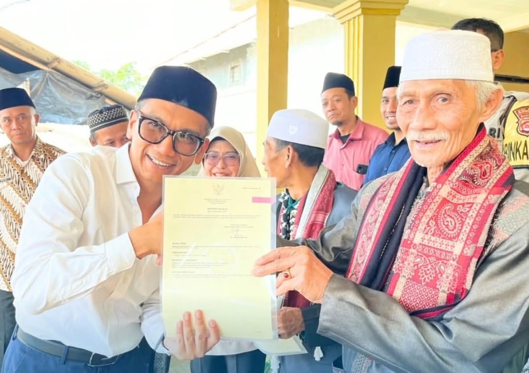 SERAHKAN SERTIFIKAT TANAH. Kepala BPN Pandeglang Fahmi secara simbolis sedang menyerahkan sertifikat tanah kepada warga penerima manfaat program PTSL di Kabupaten Pandeglang, beberapa waktu lalu. (ISTIMEWA)