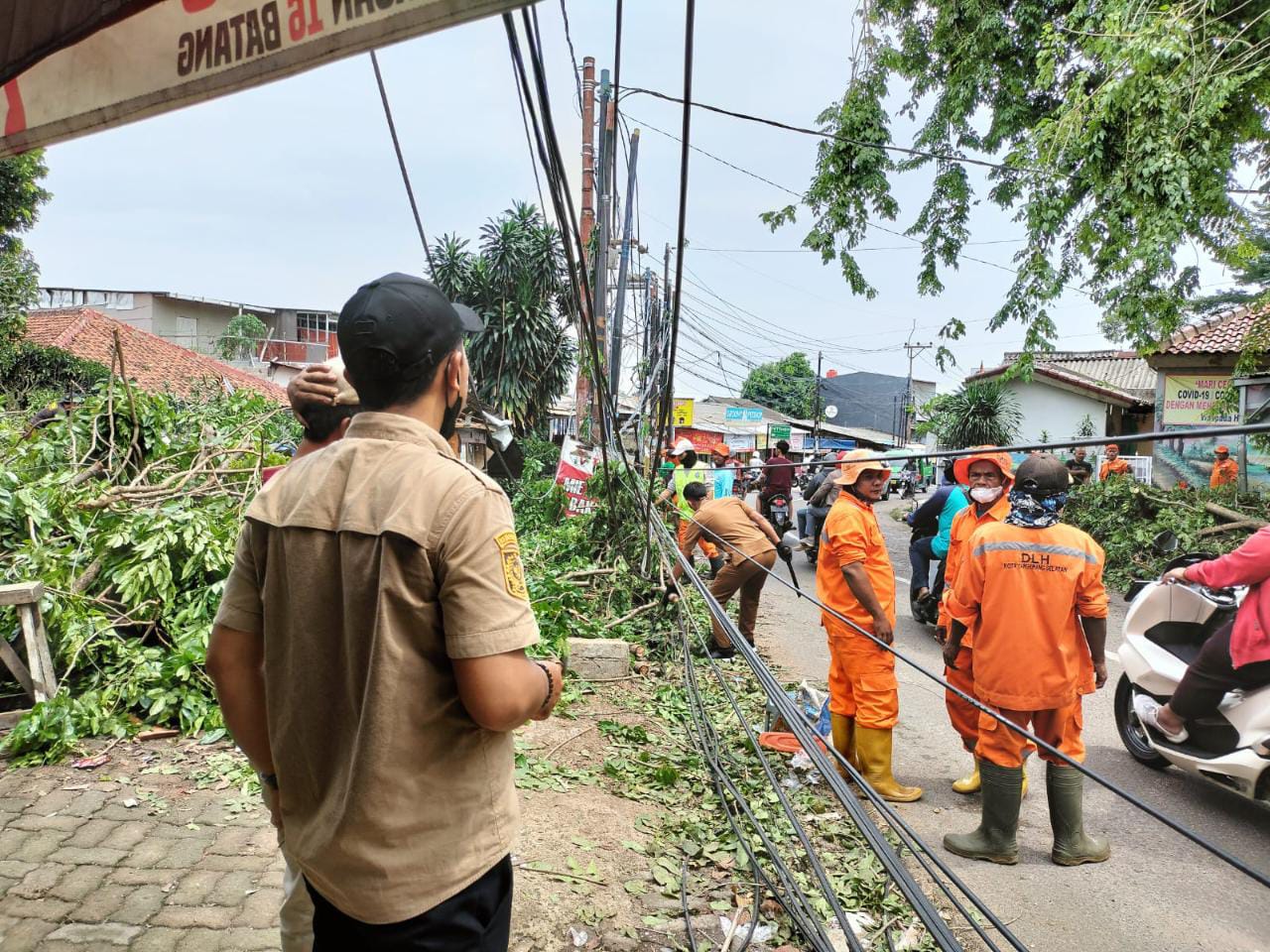 DLH Tangsel dan Pesapon Korwil Ciputat membersihkan pohon yang tumbang akibat hujan angin kemarin. (tangselpos.id/ist)