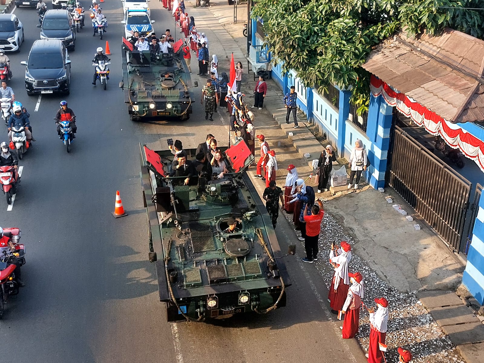 Menaiki tank tempur, Wali Kota dan Wakil Wali Kota Tangsel, Benyamin Davnie-Pilar Saga Ichsan disambut sorak sorai merdeka dari para siswa di sepanjang jalan menuju lapangan upacara. (tangselpos.id/rmn)