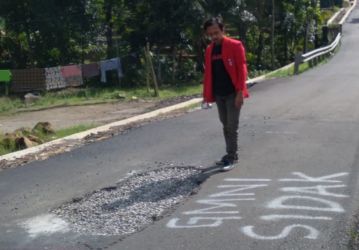 Aktivis GMNI Pandeglang menandai ruas jalan Barusatu-Koranji di Kecamatan Pulosari, yang baru dibangun dengan cat semprot, Selasa (7/6/2022).(Istimewa)