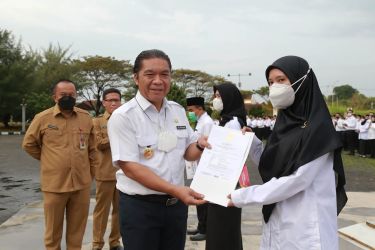 Pj Gubernur Banten Al Muktabar menyerahkan Surat Keputusan Gubernur kepada salah satu perwakilan pegawai. Foto : Humas Pemprov Banten
