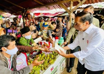 Presiden Jokowi saat membagikan bantuan uang dan sembako kepada pedagang di Pasar Baros Kabupaten Serang. (Ist)