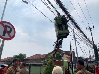 Dinas SDABMBK Kota Tangerang Selatan saat merelokasi sejumlah kabel fiber optik yang semrawut di sepanjang Jalan Ceger Raya, Pondok Aren, Tangerang Selatan, Jumat (15/7/2022). Foto : Istimewa