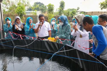 Pj Gubernur Banten Al Muktabar dan Ketua TP PKK Provinsi Banten Tine Al Muktabar melakukan penebaran ikan. (Dok. Humas Prov Banten)