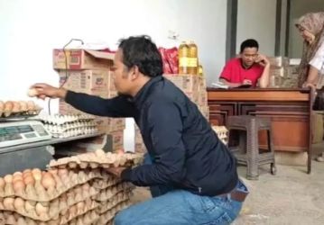 Seorang pembeli sedang memilih telor yang retak dan pecah. Foto : Istimewa
