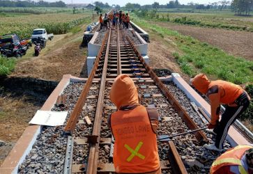 Para pekerja sedang memperbaiki rel kereta. (Ist)