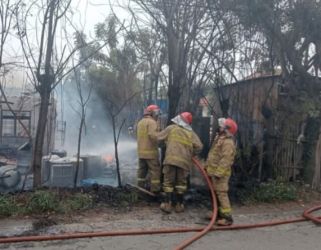 Petugas sedang memadamkan api rumah penyimpanan tiner. Foto ; Istimewa