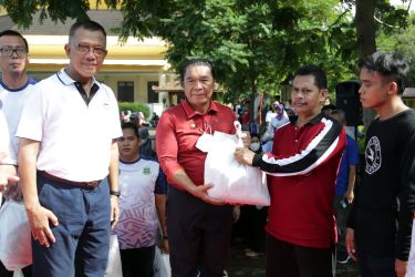 Pj Gubernur Banten Al Muktabar (kaos merah polos) saat membagikan 1.192 paket sembako kepada pramubakti. (Foto : Humas Pemprov)