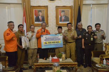 Wali Kota Tangsel Benyamin Davnie (no 4 dari kiri) saat menyerahkan bantuan sebesar Rp 500 juta untuk korban Cianjur yang diterima Bupati Herman Suherman (no 5 dari kiri) di kantor Bupati Cianjur.  (foto: Humas Pemkot)