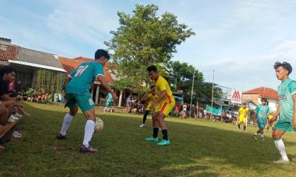 Pemain Porsip (hijau) mencoba melewati bek Anoraga (kuning).(Foto: dok/Panitia Bina Jaya Cup).