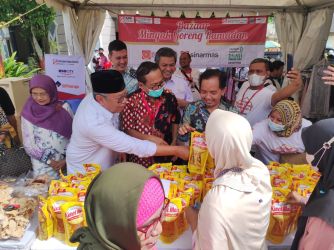 Head of Sustainability PT IKPP Tangerang Kholisul Fatikhin (kanan) bersama Walikota Tangsel Benyamin Davnie (lengan panjang putih) melayani serbuan masyarakat saat membeli minyak goreng. (din)