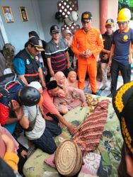 Petugas BPBD Kota Tangsel menyerahkan jenazah bocah hanyut di kali kepada keluarga korban. (din)