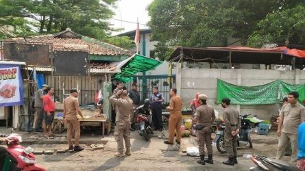 Satpol PP tengah menertibakn pedagang kiki lma yang masih berjualan di tepi jalan H Usman Pasar Ciputat, Selasa (23/5). (dra)