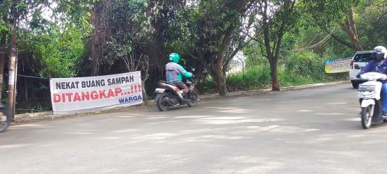 Warga sekitaran pacuan kuda, Kecamatan Pamulang memasang spanduk larangan membuang sampah liar bertulisan 'NEKAT BUANG SAMPAH DITANGKAP’. (dra)