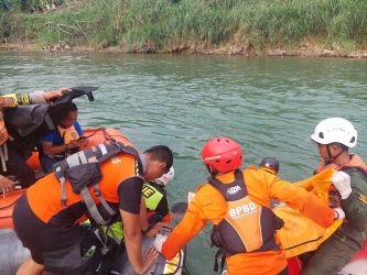 Petugas BPBD Kota Tangsel melakukan evkauasi jenazah korban tenggelam di Sungai Cisadane, Senin (21/8).(dra)