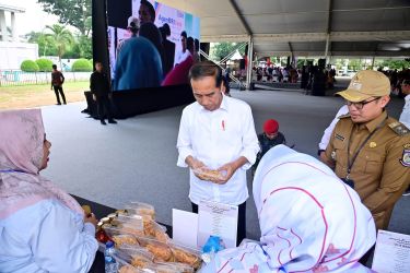 Presiden Jokowi mengamati produk UMKM dari Kota Tangsel saat acara di Cilenggang, Serpong, kemarin.(dra)