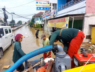 Petugas saat mengoperasikan pompa air di lokasi banjir Pondok Maharta, Selasa (8/7).