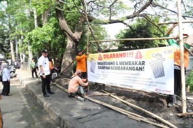 Petugas tampak memasang rambu larangan membuang sampah sembarangan usai resmi menutup Tempat Pembuangan Sampah (TPS) liar yang berada di tikungan marga portal atau Jalan Taman Makam Pahlawan Taruna, Kelurahan Sukasari, Kecamatan Tangerang pada Rabu (9/7).