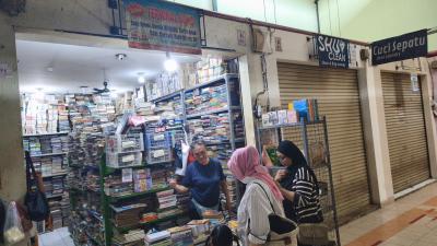 Ibu Leni, pemilik Terminal Buku, tengah melayani pelanggan yang mencari koleksi bacaan. Selain berjualan langsung di toko, Terminal Buku juga memasarkan buku-bukunya melalui berbagai platform marketplace untuk menjangkau lebih banyak pembaca. Foto : Ist